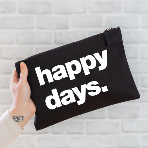 an oversized black cotton canvas pouch with the slogan 'happy days' printed in neon white