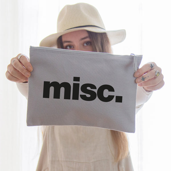 A really useful oversized canvas pouch printed with the slogan 'misc' in black