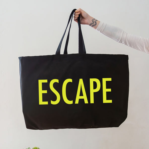 black oversized tote bag with large neon yellow escape text