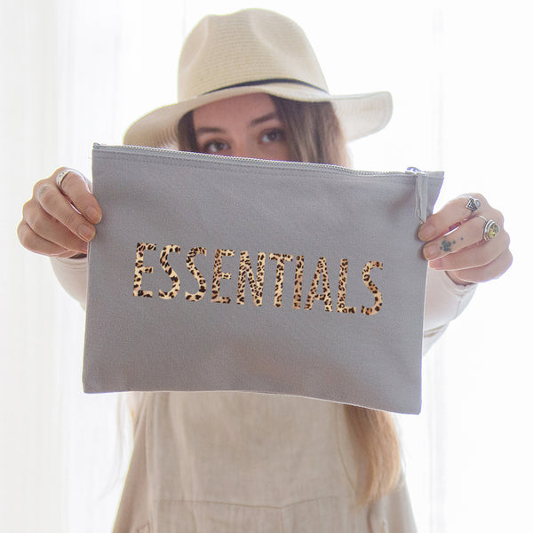 a really useful oversized grey pouch printed in leopard print with the slogan 'essentials'