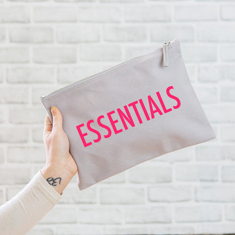 a really useful oversized grey pouch printed in neon pink with the slogan 'essentials'