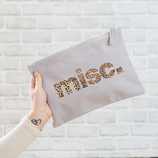 A really useful oversized canvas pouch printed with the slogan 'misc' in leopard print