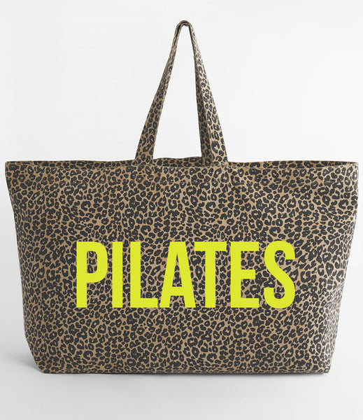 Leopard print tote bag with 'PILATES' in neon yellow on a white background