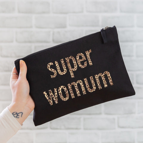 an oversized black cotton canvas pouch printed with the slogan 'super womum' in leopard print