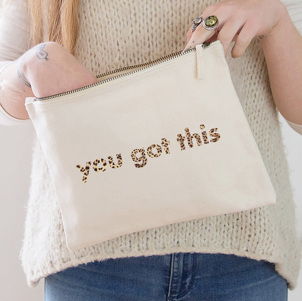an oversized natural coloured pouch bag printed with the slogan 'you got this' in leopard print